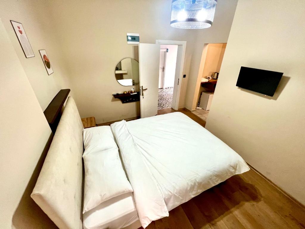 a bedroom with a bed with white sheets at Mustafa Tokalaç Castle house in Marmaris