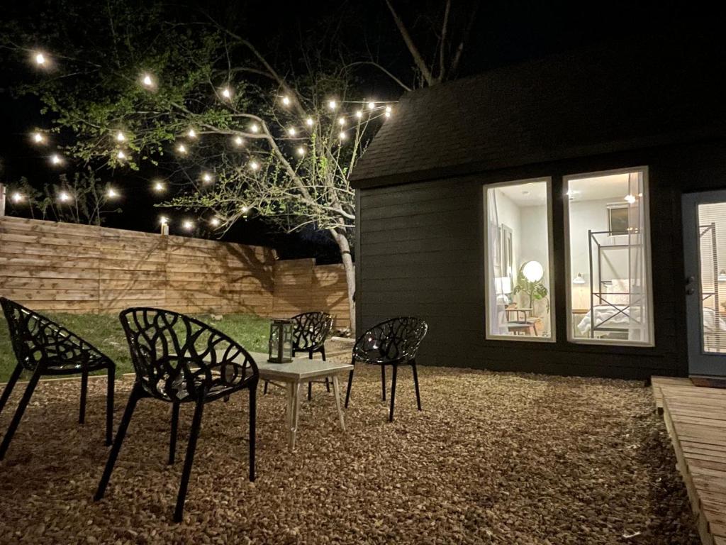 four chairs and a table in a backyard at night at Downtown Views, Rooftop Deck, Pets in Dallas