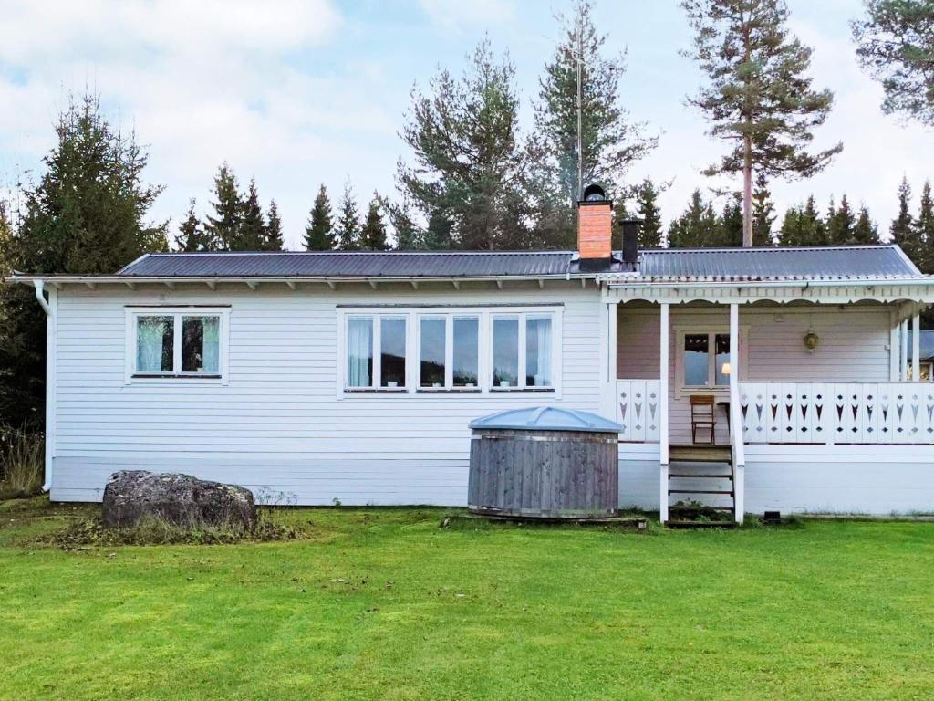 a white house with a lawn in front of it at Holiday home BOLLNÄS in Bollnäs