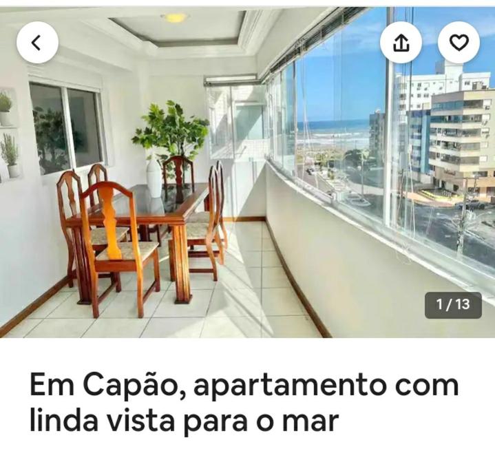 a balcony with a table and chairs in a room at Ap em Capão da Canoa in Capão da Canoa