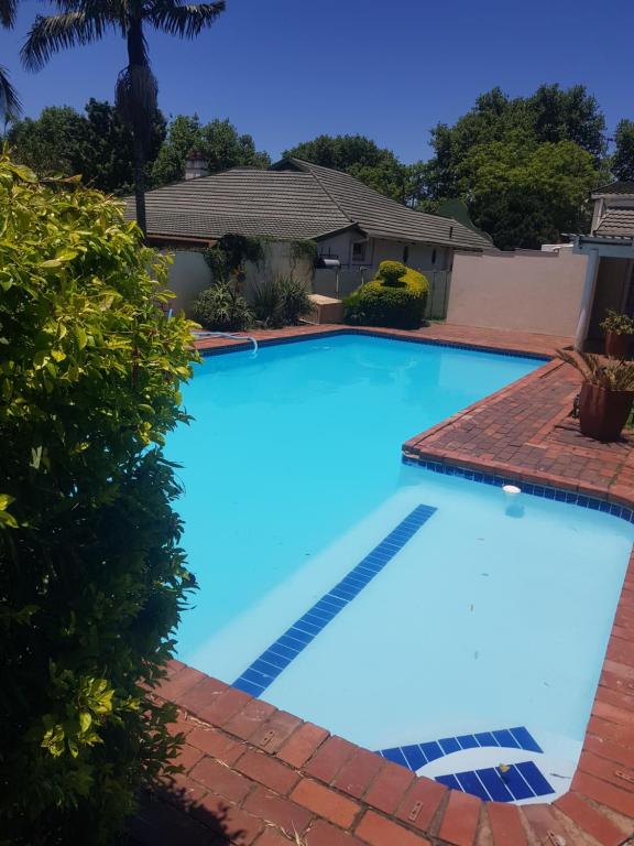 a large blue swimming pool in front of a house at Fabulous guest house in Pietermaritzburg