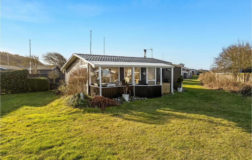 een klein huis in een tuin met een grasveld bij Gorgeous Home In Lgstr With Kitchen in Løgstør