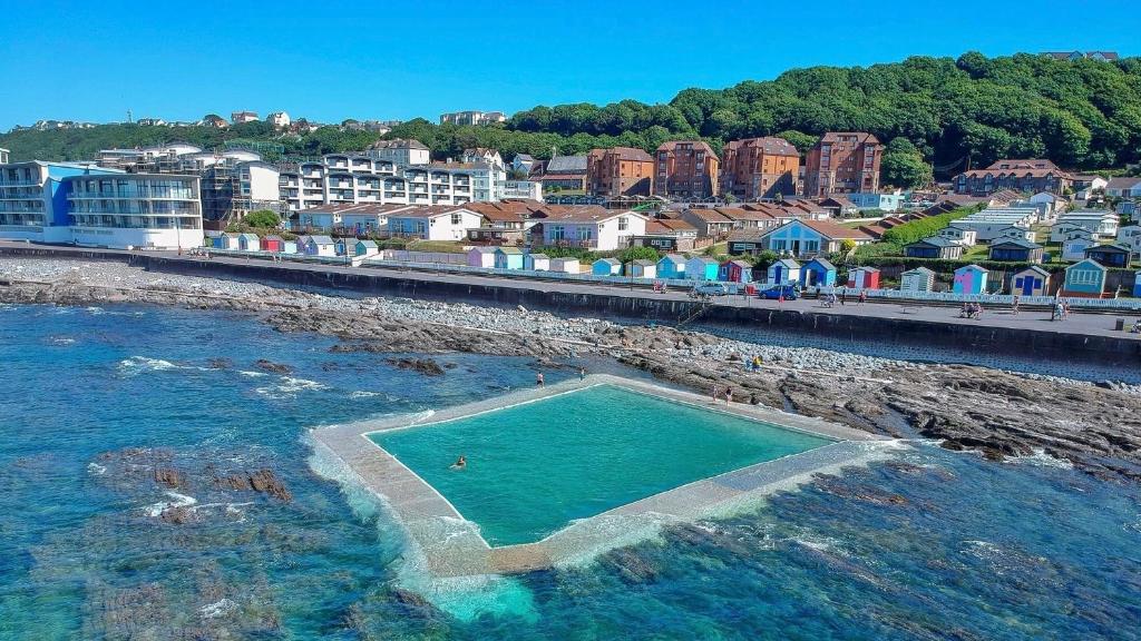 a swimming pool in the water next to a city at Lundy SeaView Great Sea-views in Westward Ho