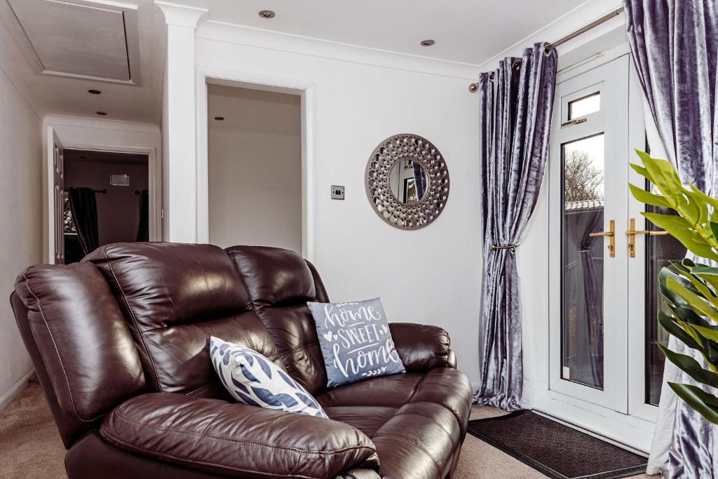 brązowy, skórzany fotel w salonie w obiekcie Willow Chalet near Cartmel & Lake Windermere w mieście Flookburgh