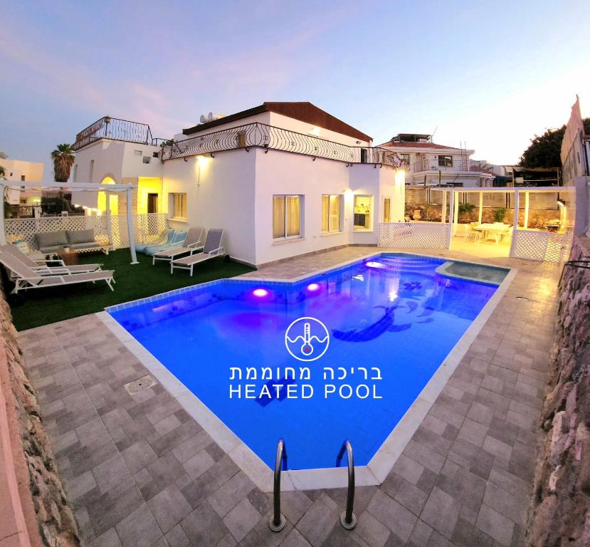 uma villa com piscina aquecida num bairro residencial em VILLA SHUNIT- וילה שונית by barak royal suites em Eilat