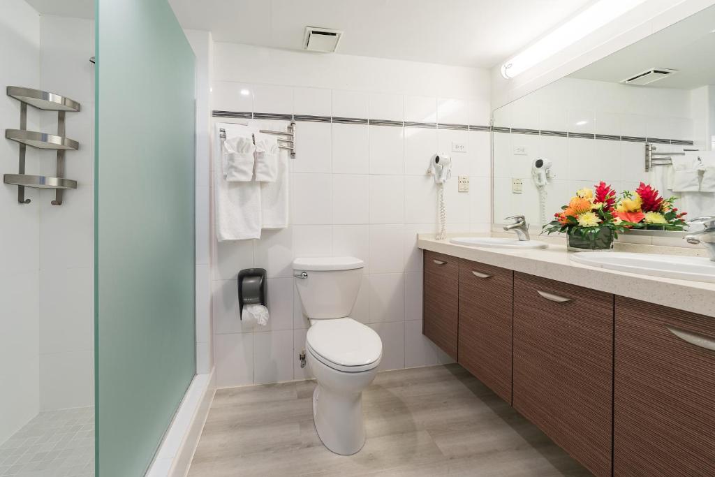 a white bathroom with a toilet and a sink at La Vista Resort in Simpson Bay