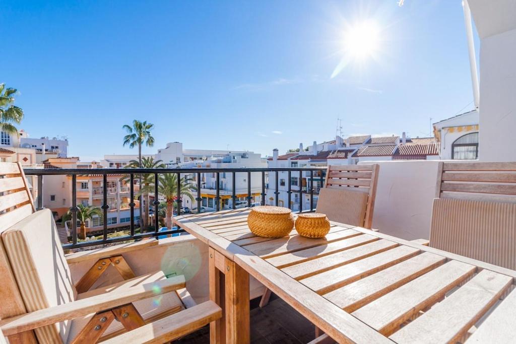 drewniany stół na balkonie z widokiem w obiekcie Canovas Nerja - Alcazaba Parador, piscina, 2 dorm w mieście Nerja