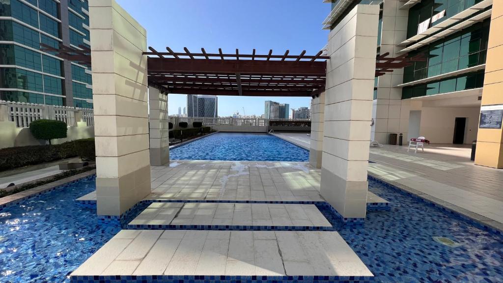 una piscina en medio de un edificio en Prestigeo Guest House Abu Dhabi, en Abu Dabi