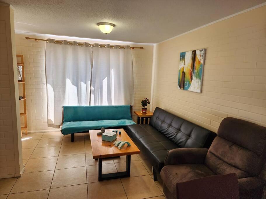 uma sala de estar com um sofá e uma mesa em Casa a pocos minutos de playa La Herradura em Coquimbo