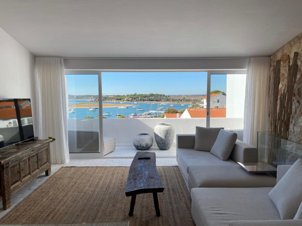 a living room with a couch and a large window at Alvor River & Sea View in Alvor