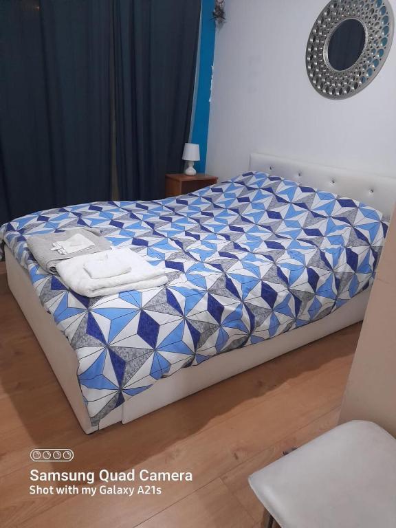 - un lit avec une couette bleue et blanche dans l'établissement Beautiful 1 bedroom Ground floor with shared bathroom, à Londres