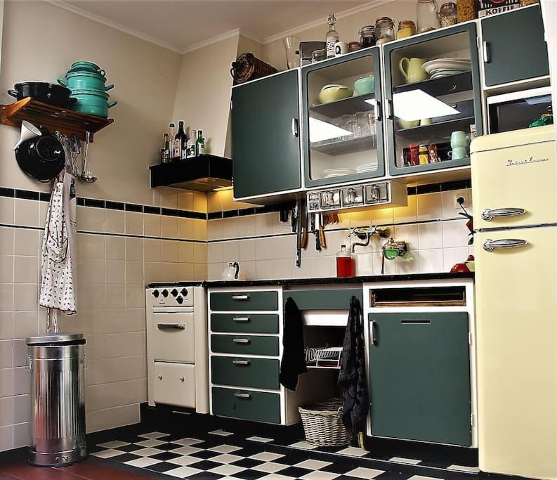 een keuken met groene kasten en een geruite vloer bij Onthaast & Geniet in Den Helder
