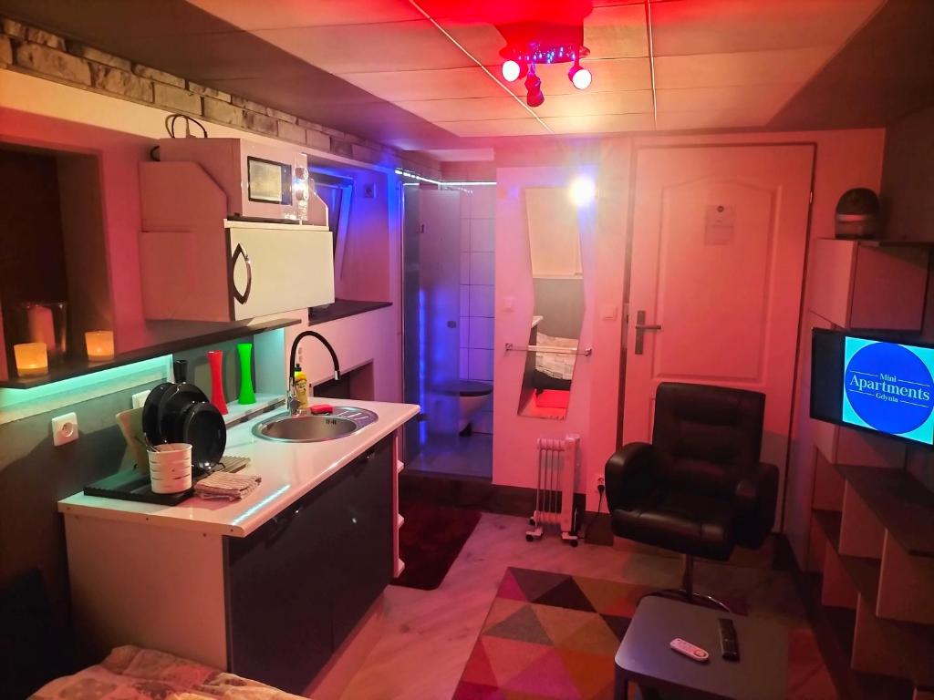 a room with a kitchen with pink and blue lights at 24h Gdynia Mini Apartamenty na kod dostępu & free parking & no keys in Gdynia