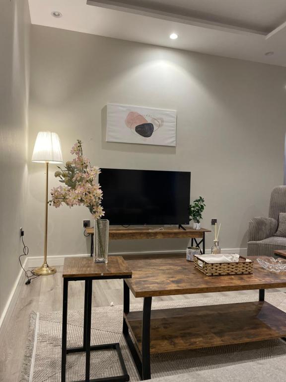 ein Wohnzimmer mit einem Couchtisch und einem Flachbild-TV in der Unterkunft شقة دخول ذاتي Modern Apartment North Ring110 in Riad