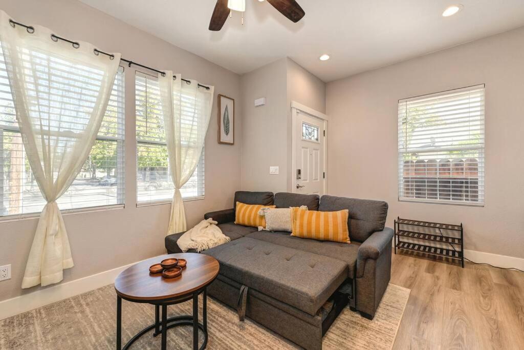 a living room with a couch and a table at Sacramento Two-Story Condo Near Oak Park Brewing! in Sacramento