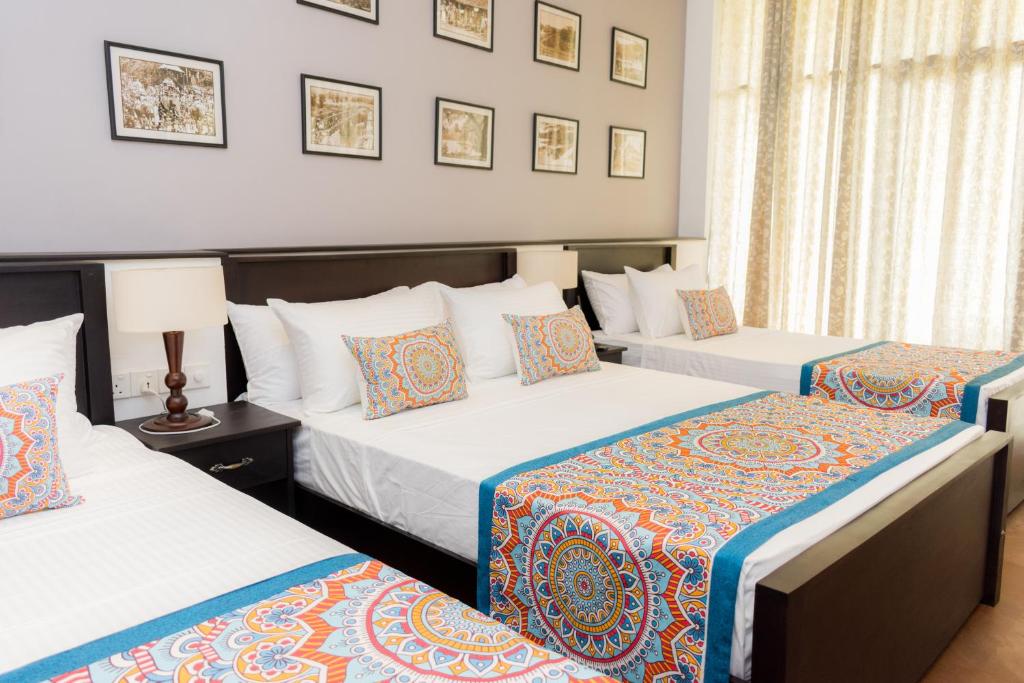 um quarto de hotel com duas camas e duas lâmpadas em Kandy City View em Kandy