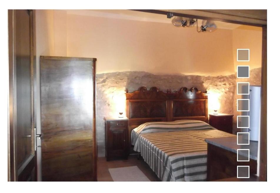 a bedroom with a bed with a wooden head board at A Casa Di Mì Appartamenti vacanza in Montefalco