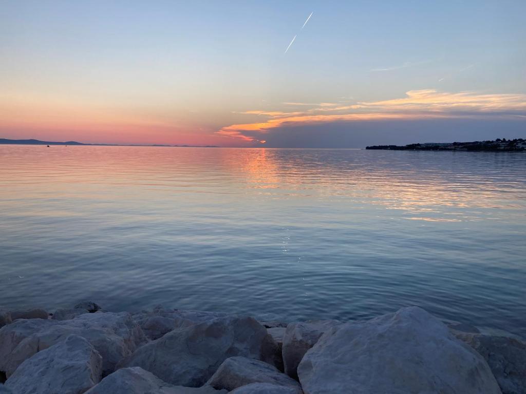 een zonsondergang boven een grote hoeveelheid water bij Maris apartments, Petrčane in Petrcane