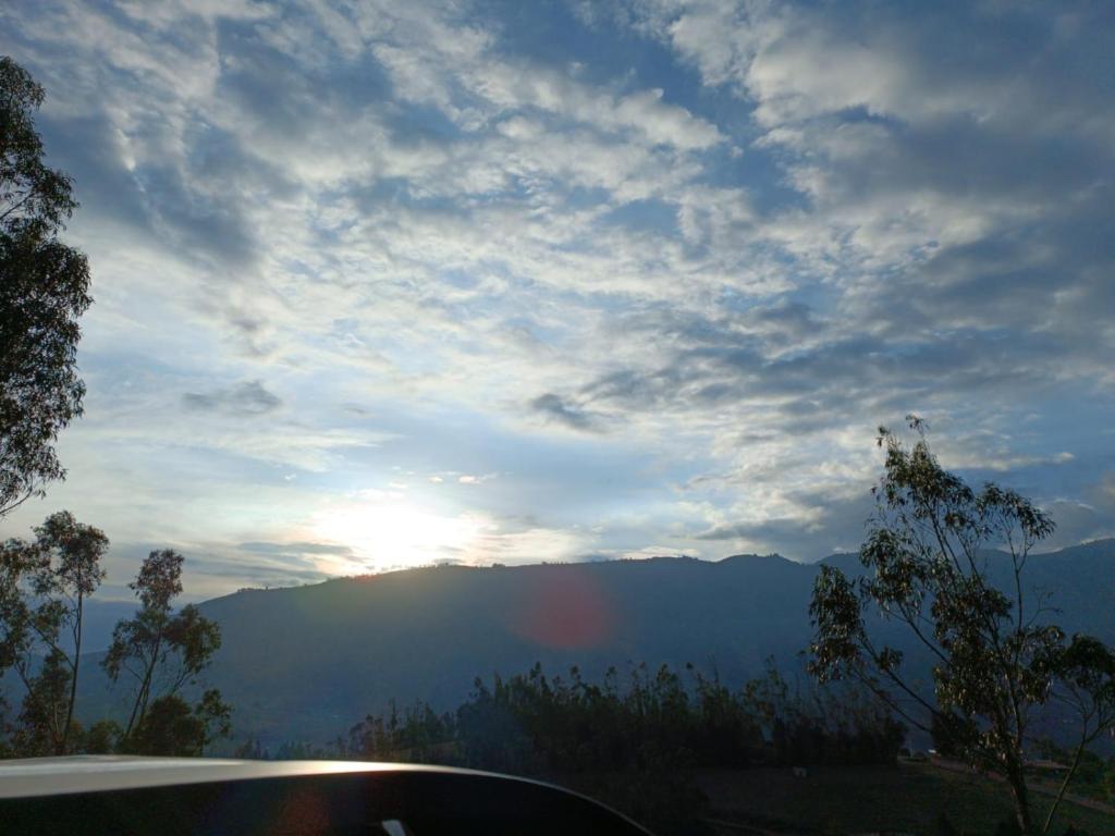 a view of the sun setting over a mountain at Hostal NOA El Valle in Quito