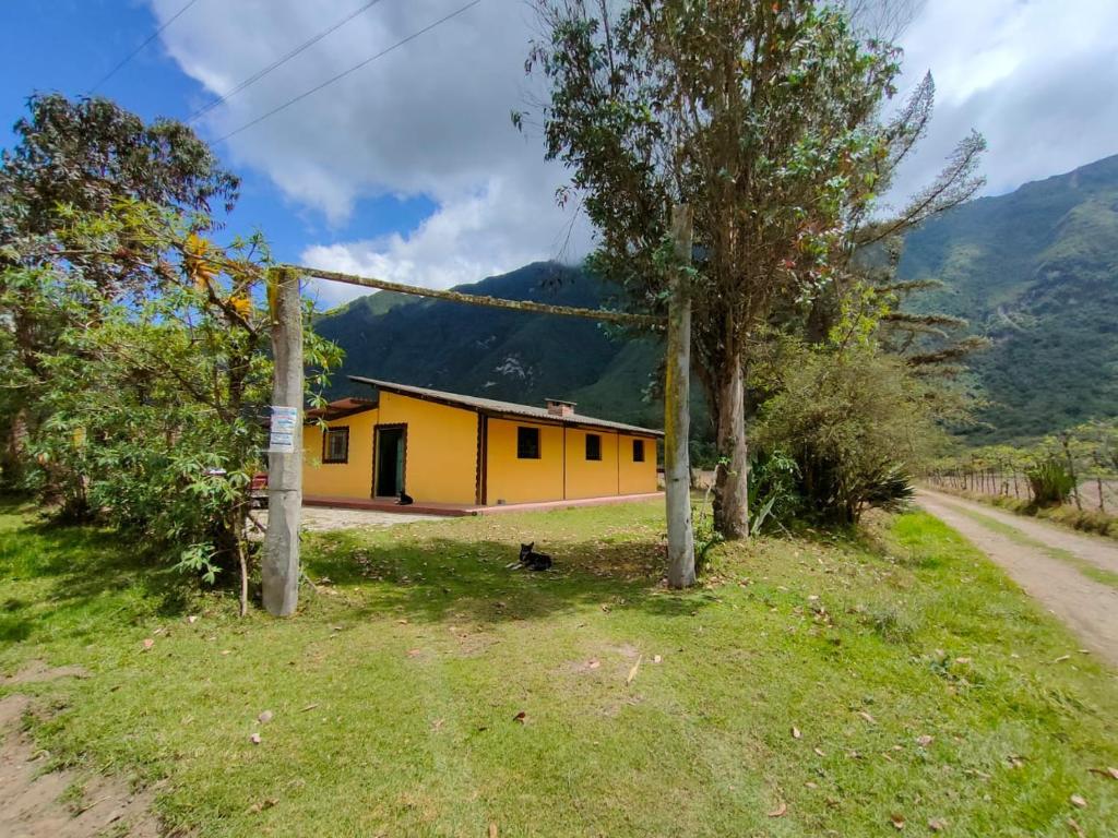 een geel huis aan de kant van een weg bij Pululahua Magia y Encanto in Quito