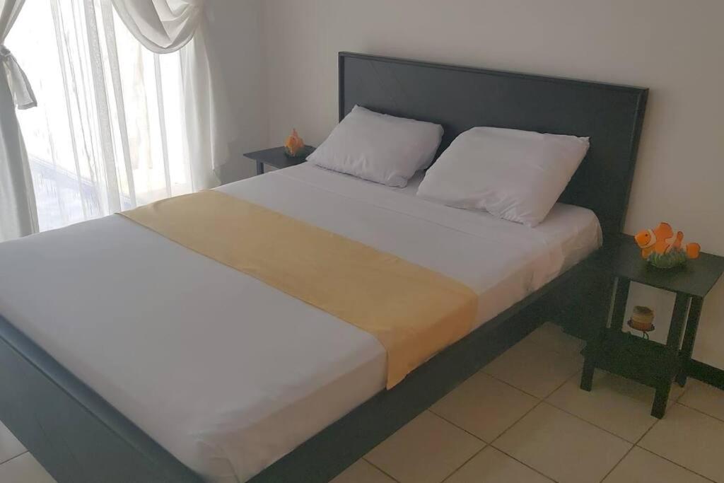een slaapkamer met een groot bed met een zwart hoofdeinde bij Casa vacacional Playa Herradura in Herradura