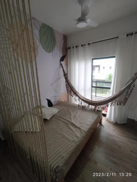 Cette chambre dispose d'un lit pliant et d'une fenêtre. dans l'établissement Kitpraiana Ocean, à Praia Grande