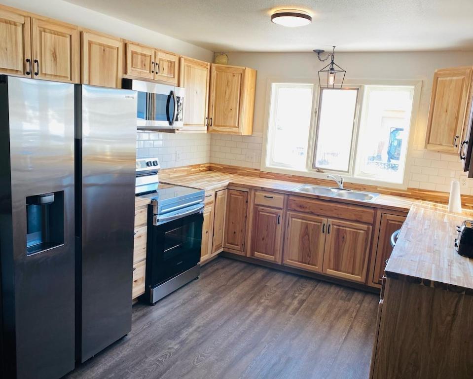 una cocina con nevera de acero inoxidable y armarios de madera en :::Hillsboro Inn - Apartment:::, 