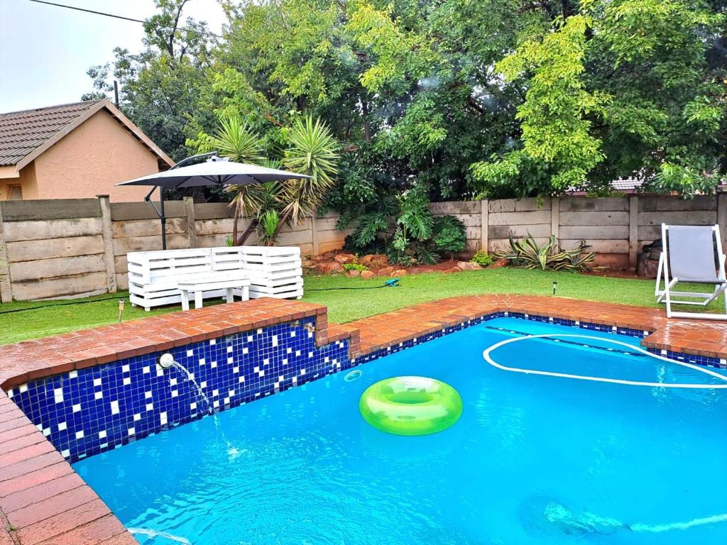 a swimming pool with a green frisbee in the water at Horizon Green Guest House in Randfontein