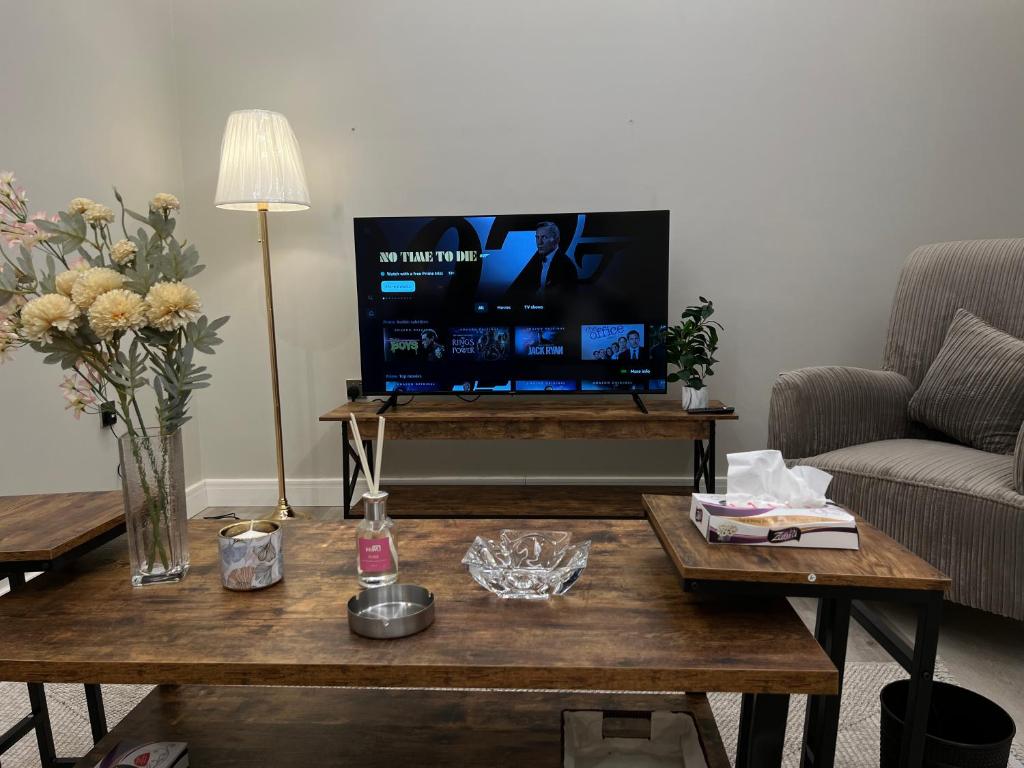 een woonkamer met een salontafel en een flatscreen-tv bij شقة دخول ذاتي بجلسة خارجيةModern Apartment North Ring 319 in Riyad