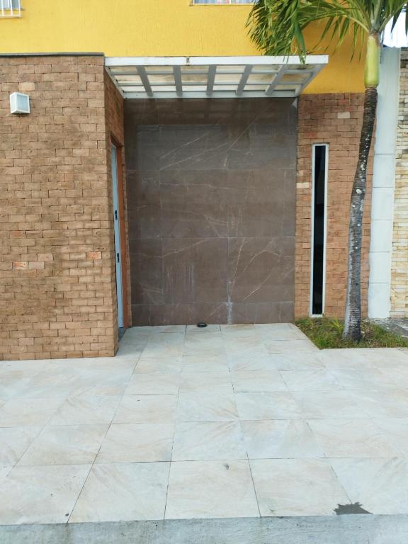 a garage with a brown garage door and a brick wall at Residencial Letícia Miranda in Aracaju