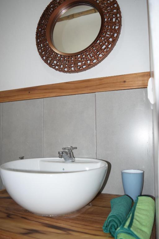 a bathroom with a white sink and a mirror at Bungalows Ayampe in Ayampe
