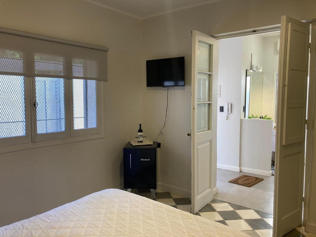 1 dormitorio con 1 cama y TV en la pared en Gomez Point Mendoza en Mendoza