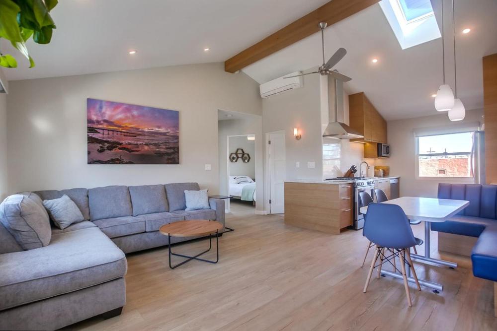 a living room with a couch and a table and a kitchen at 7BD Family, Event Friendly, 2 blocks to Beach, Boardwalk in San Diego