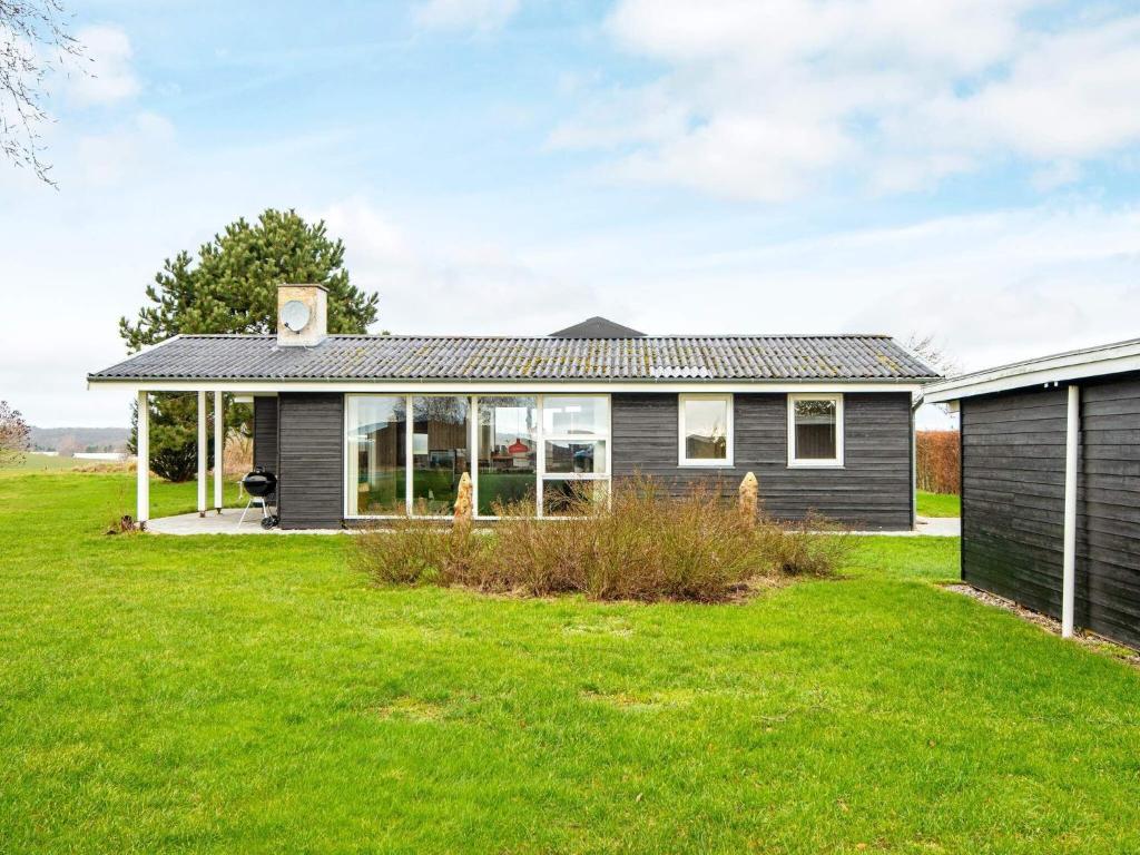 a house with a green lawn in front of it at 8 person holiday home in Ebeltoft in Ebeltoft