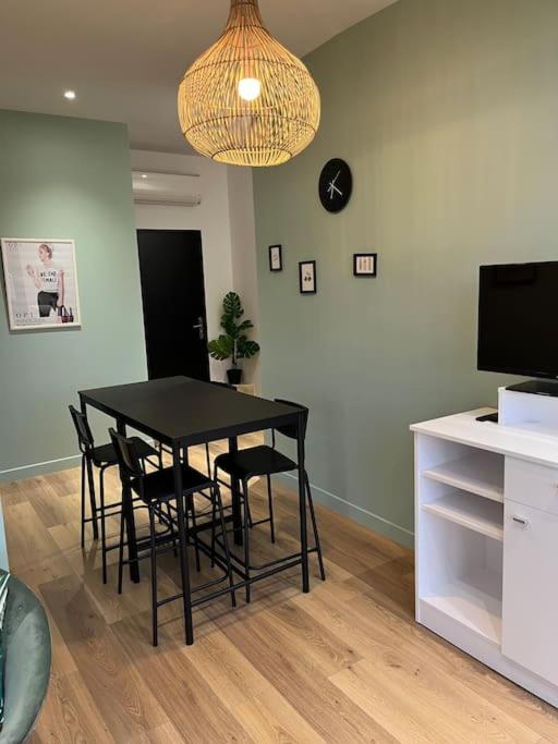 une salle à manger avec une table et des chaises noires dans l'établissement Maison Origine Périgueux, à Périgueux