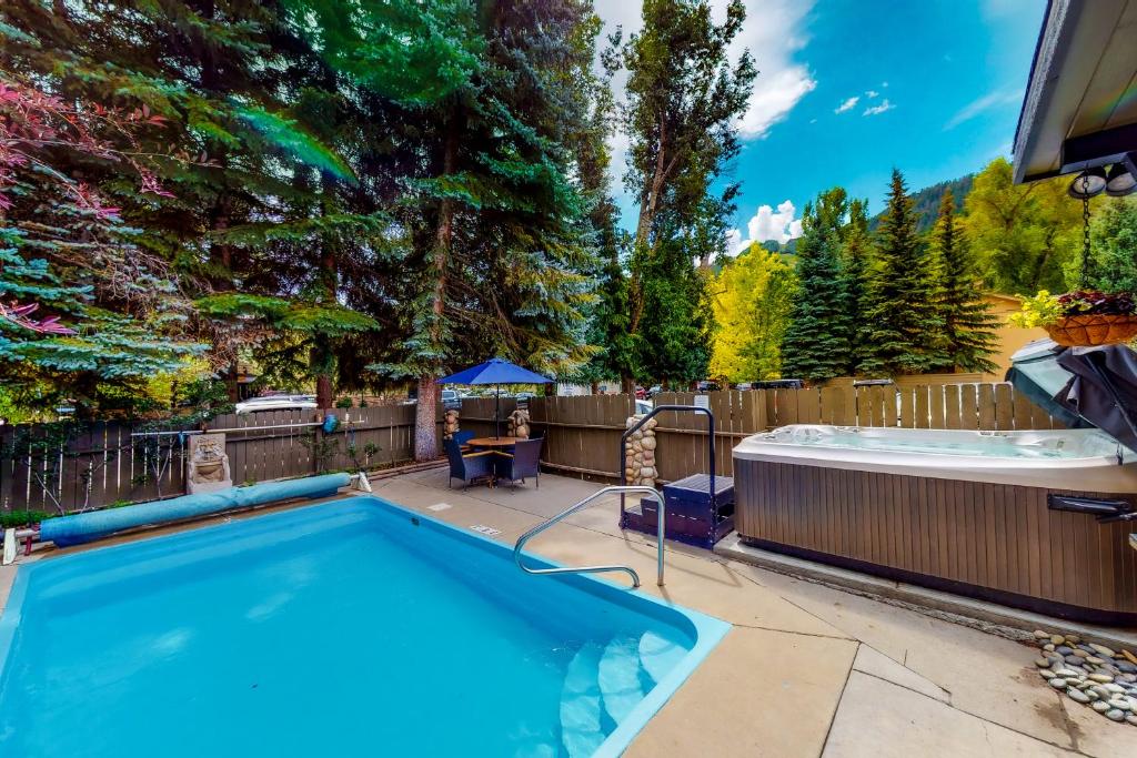 - une piscine dans un jardin avec un bain à remous dans l'établissement Aspen Mountain Lodge, à Aspen