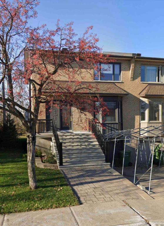 a brick house with a staircase in front of it at Heaven Is A Place On Earth in Montreal