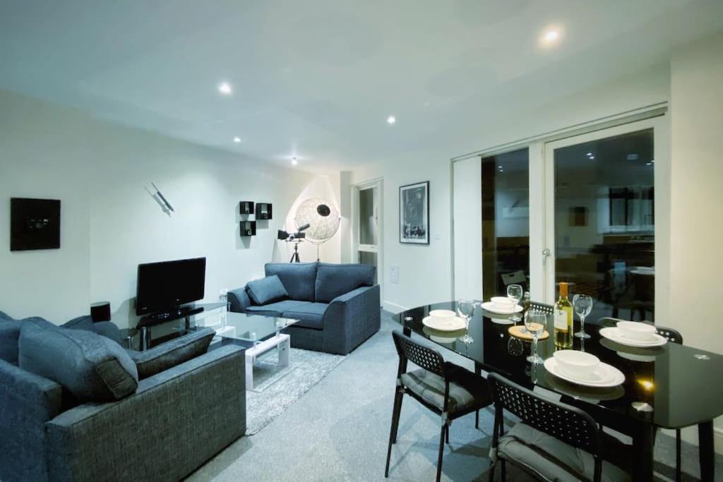 sala de estar con sofá y mesa con sillas en Two Bedroom Luxury Apt with film style, en Swansea