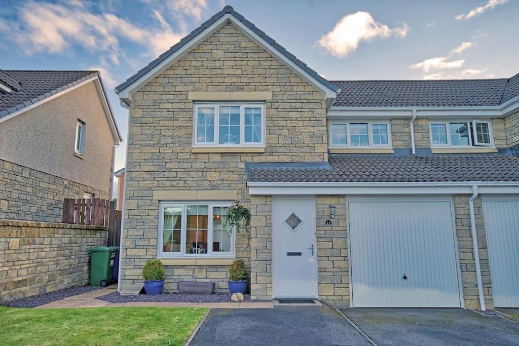 a large brick house with a white garage at Three bedroom house in Culloden, Inverness in Culloden