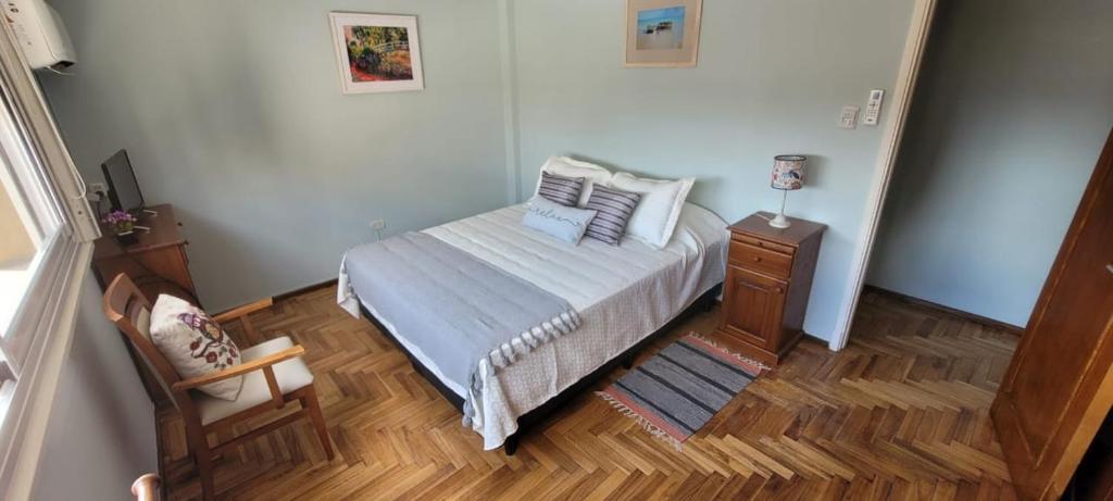 una piccola camera con letto e pavimento in legno di Departamento temporario pateto a Córdoba