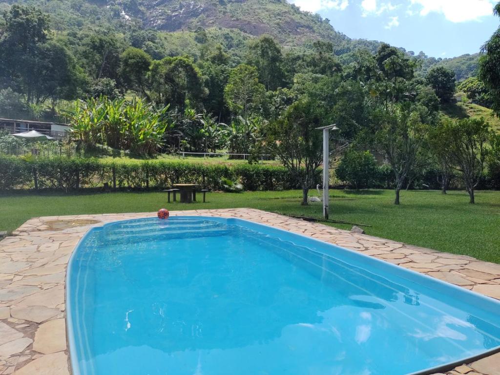 a swimming pool with a view of a garden at Sítio das Jaqueiras in Bom Jardim