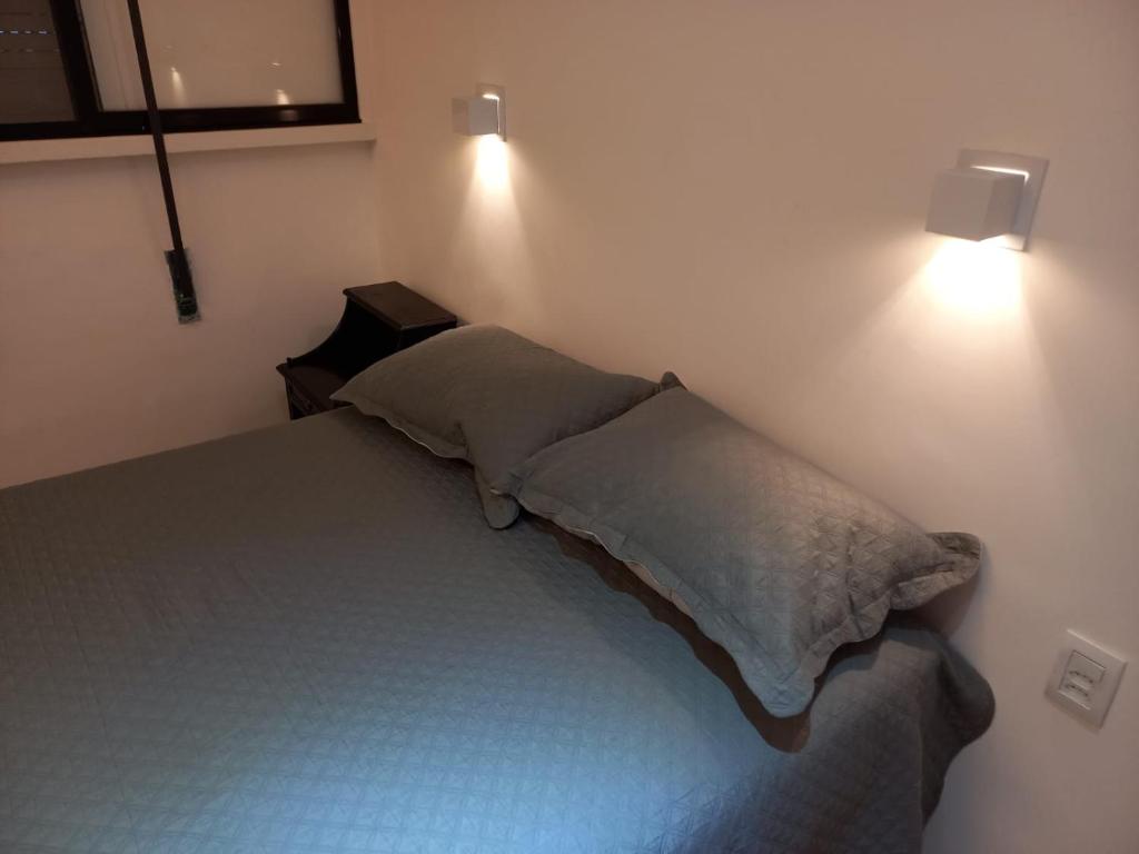 1 dormitorio con 1 cama con 2 luces en la pared en Luxo 2 suites Copacabana, en Río de Janeiro