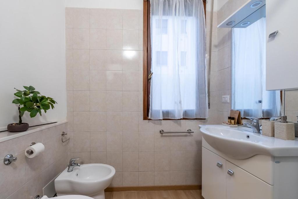 un bagno bianco con un water e un lavandino di Suite 1,2 porta Milano centro parking free a Milano