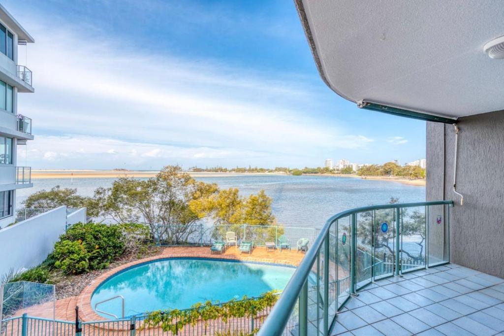 a balcony with a swimming pool and a view of the water at 4shore@waterfrontplace in Maroochydore