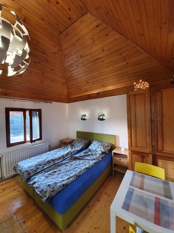 a bedroom with a bed and a wooden ceiling at Bungalov Zahej Divčibare in Divčibare