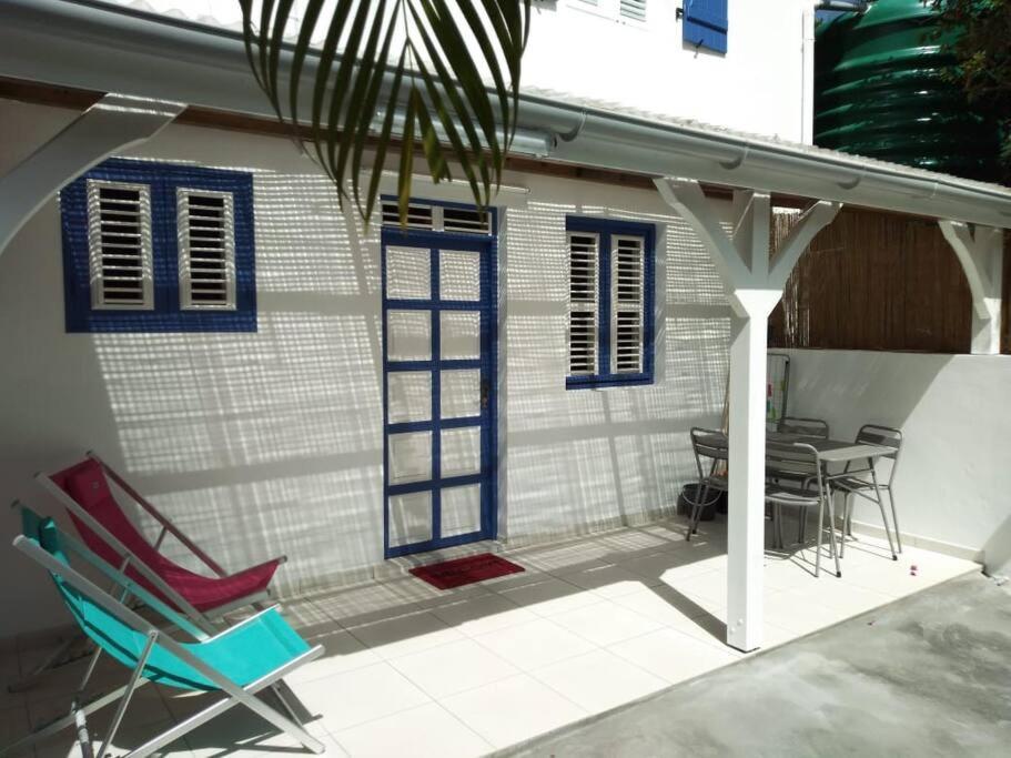 une terrasse avec des chaises et une table ainsi qu'une maison dans l'établissement Villa Campêche Azur, au Marin