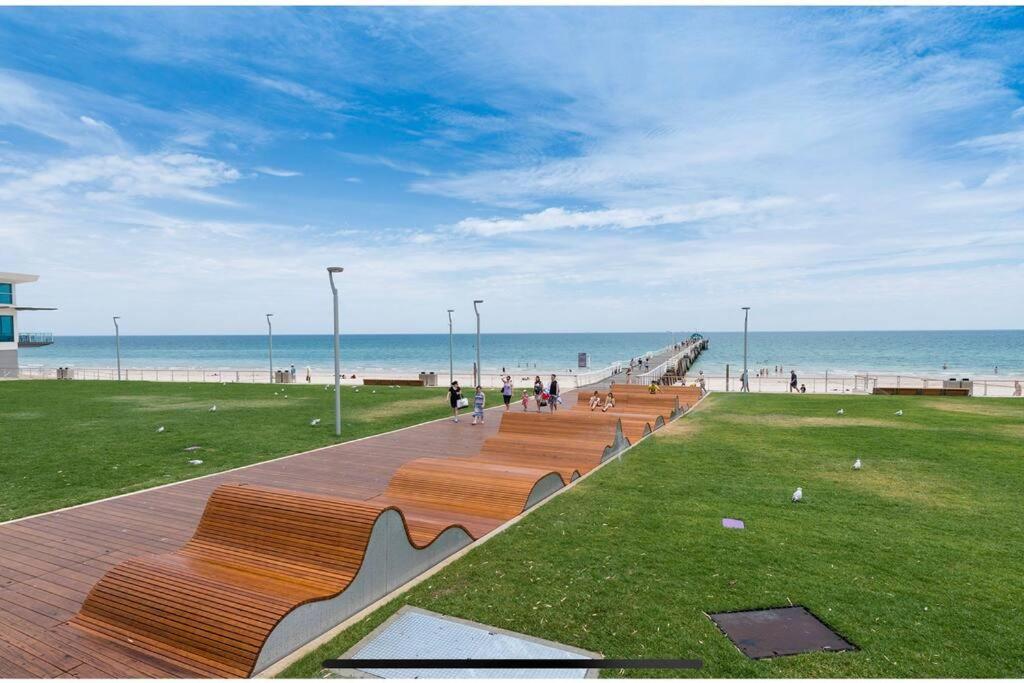 a row of benches sitting next to the beach at Rawsons shack Beachfront unit suits single or couple in Henley Beach South
