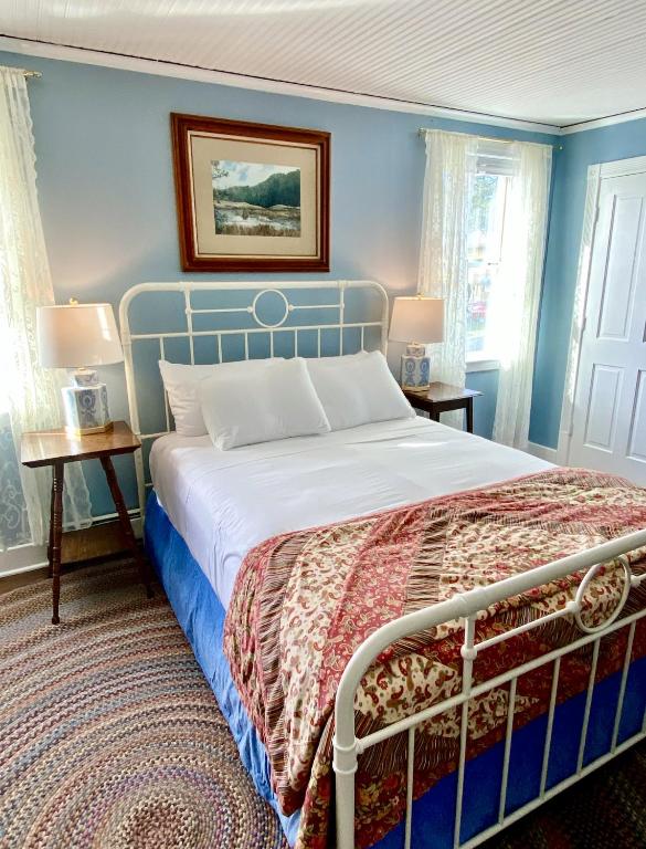 a bedroom with a bed with blue walls and windows at Orcas Hotel in Orcas