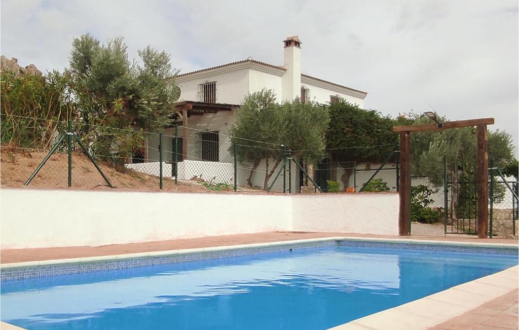 una piscina azul frente a una casa en Gorgeous Home In Caete La Real With Private Swimming Pool, Can Be Inside Or Outside, en Cañete la Real