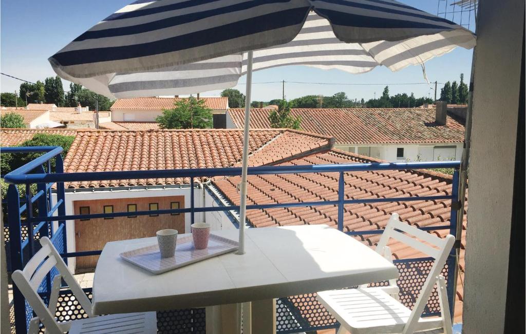 una mesa y una sombrilla en el balcón en Stunning Apartment In L Aiguillon Sur Mer With Kitchenette, en LʼAiguillon-sur-Mer